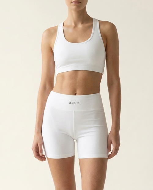SECOND. organic cotton sports bra and bike short set in white, front view on a bone studio background