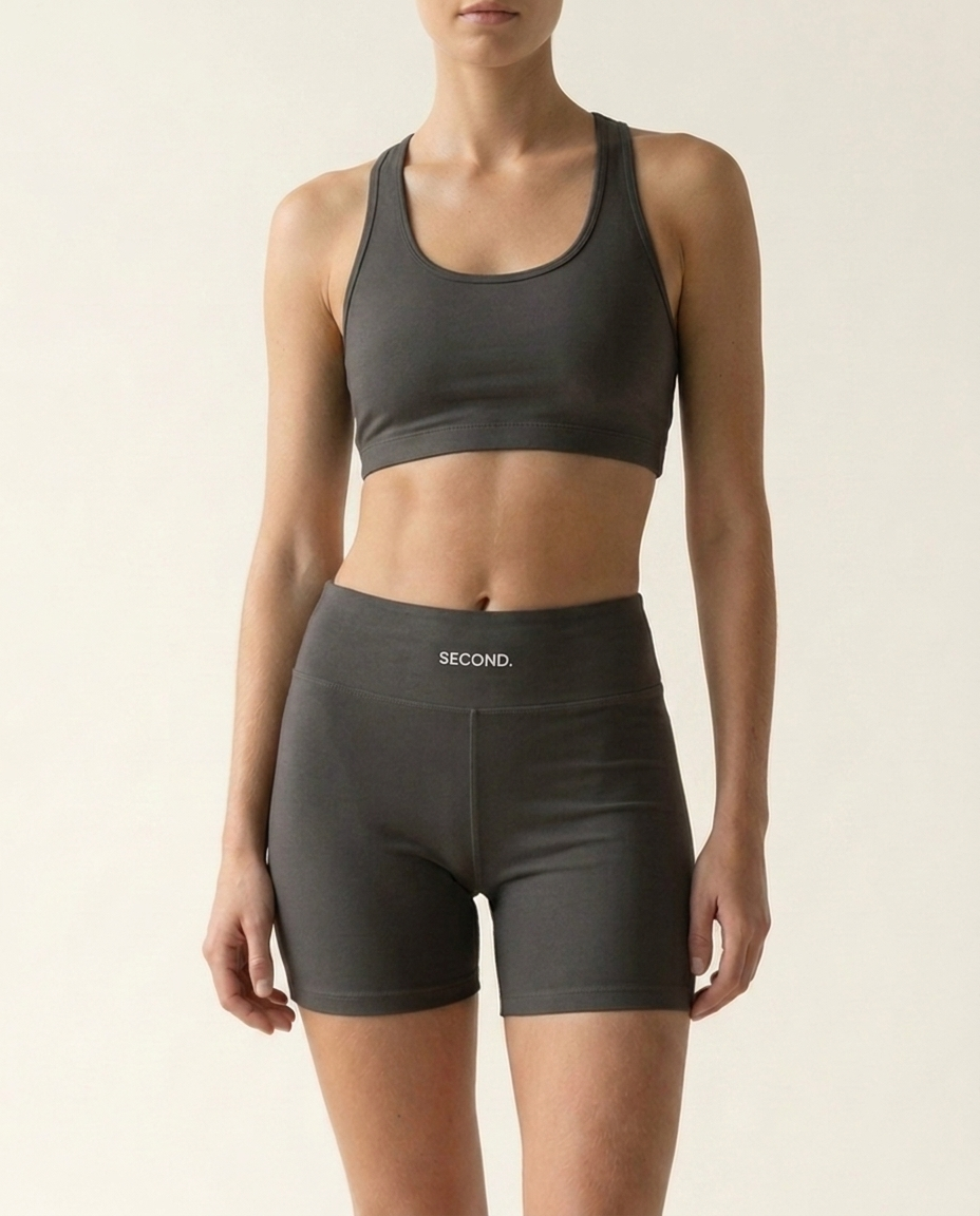 SECOND. organic cotton sports bra and shorts set in charcoal, front view on a bone studio background